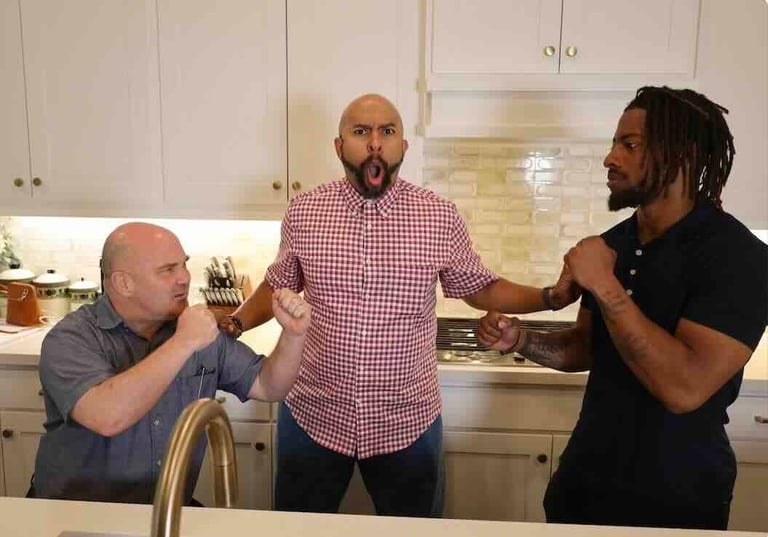 Three men having a conversation in a modern kitchen with white cabinets and stainless steel appliances